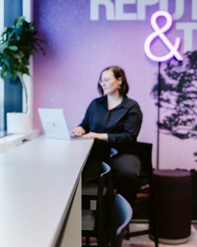 Moderni toimiston sisääntulo ja lounge-alue, jossa brändin mukaiset värit ja valaistus luovat viimeistellyn ensivaikutelman