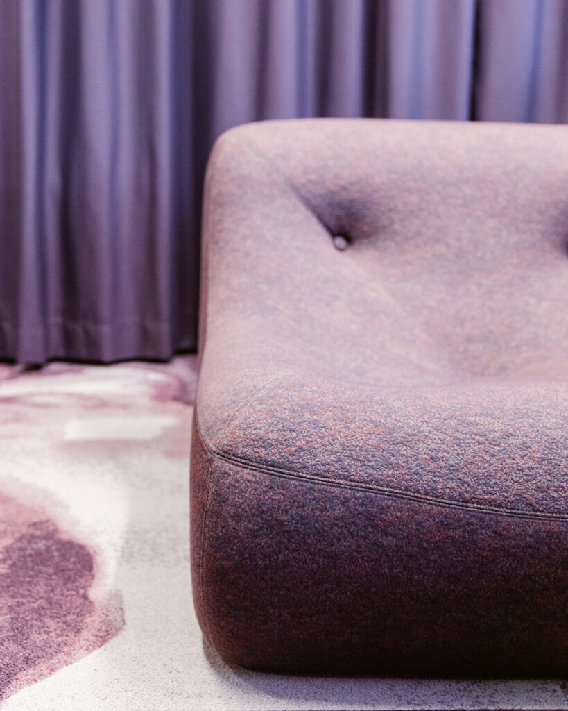 Toimiston lounge-tila asiakastapaamisille ja yhteisille hetkillä, kalustus ja valaistus suunniteltu brändin mukaisesti