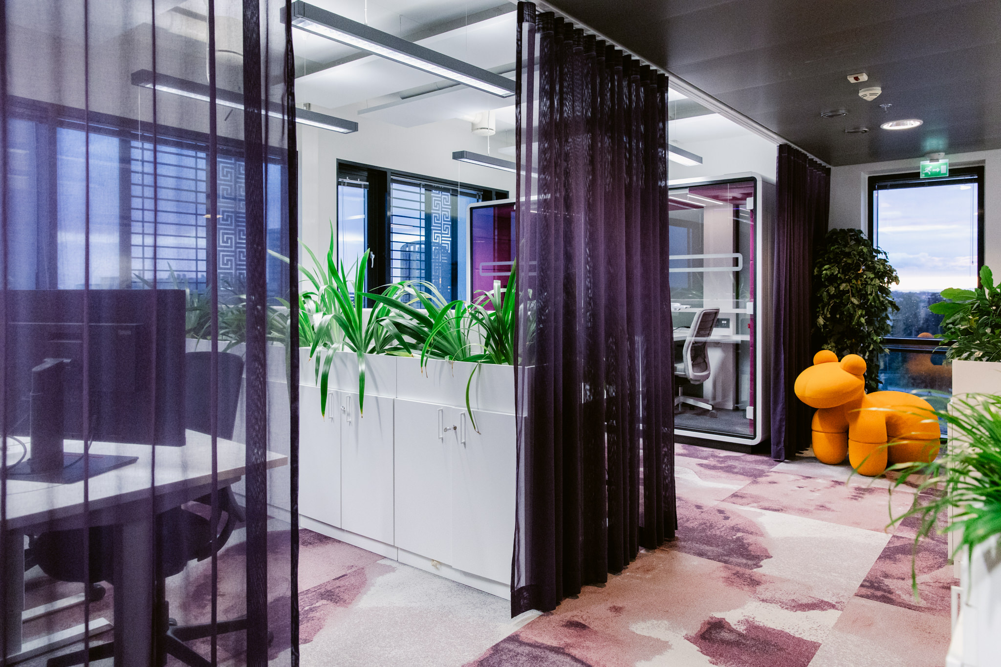 Toimiston avotyötila, jossa rauhallinen värimaailma ja selkeä kalustus luovat miellyttävän työympäristön