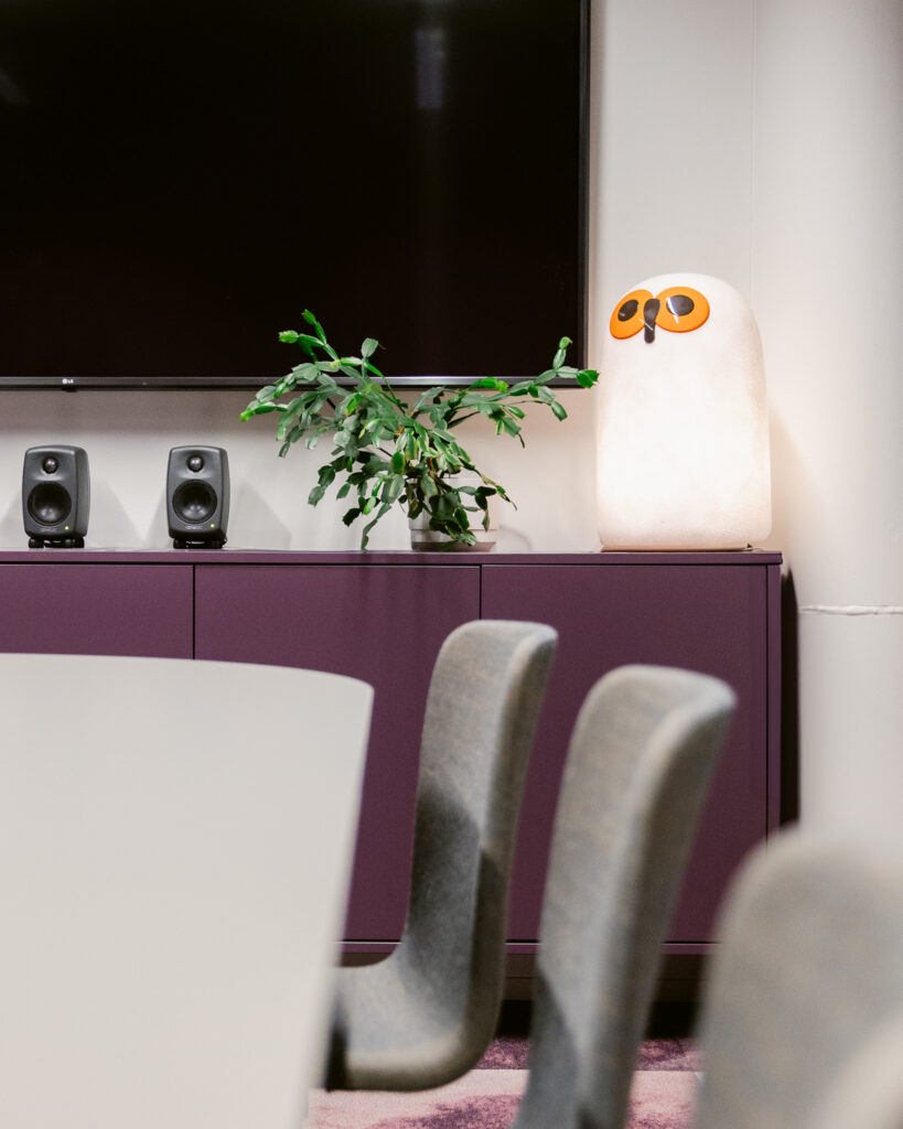 Työympäristön neuvottelutila, jossa brändi-ilme näkyy yksityiskohdissa ja materiaalivalinnoissa