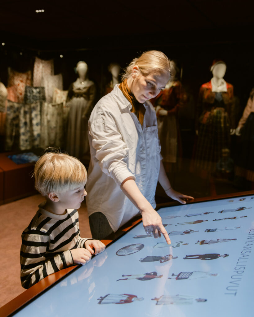Näyttelyarkkitehtuuri museossa – Suomen kansallispukukeskus Näyttelyarkkitehtuuri museossa Suomen kansallispukukeskuksen pysyvässä näyttelyssä.