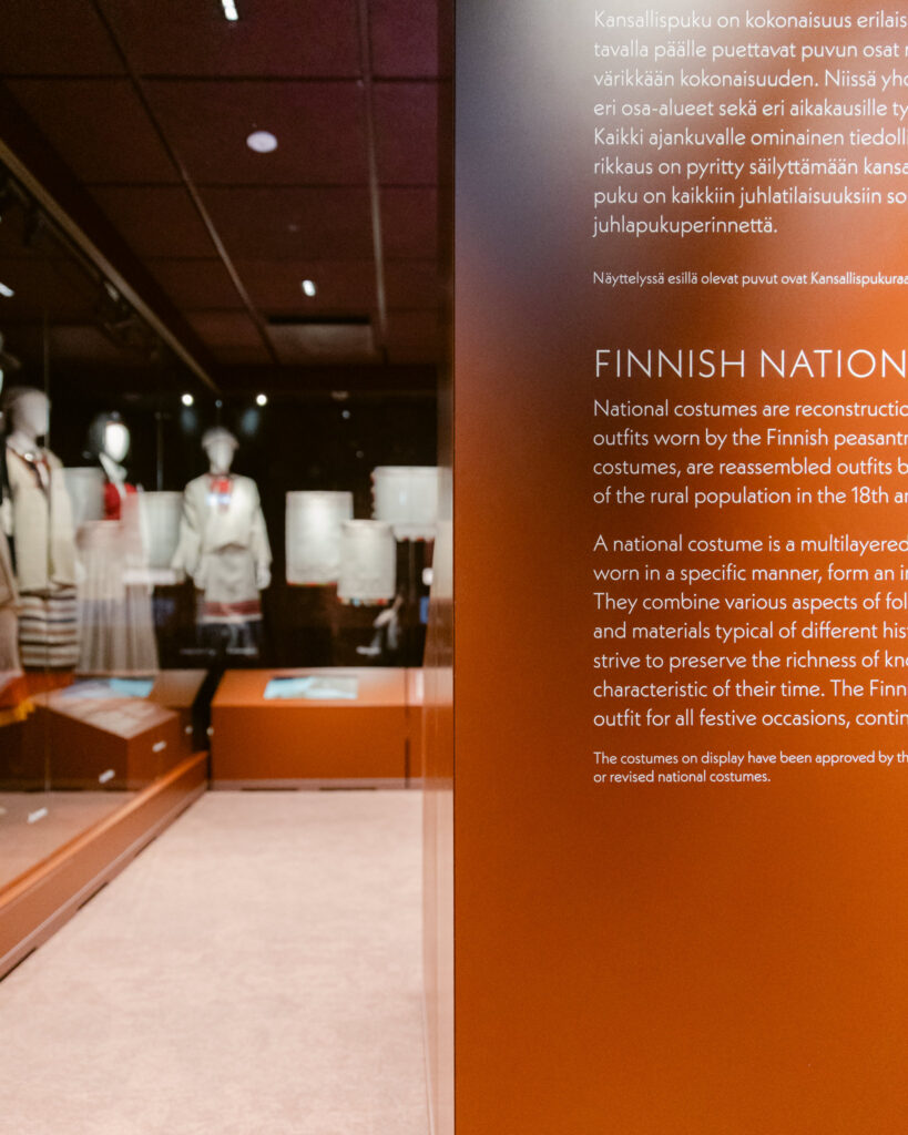 Vitriinit osana näyttelyarkkitehtuuria Näyttelyarkkitehtuuri museossa, jossa vitriinirakenteet tukevat kansallispukujen museaalista esillepanoa.