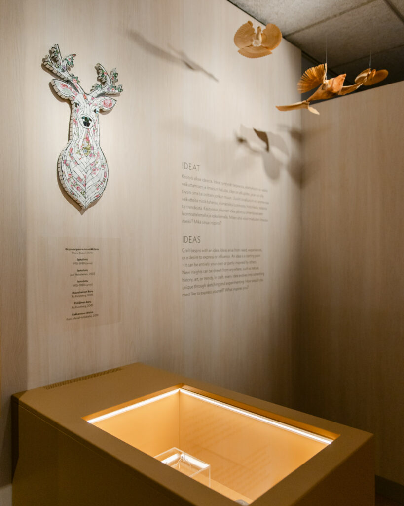 Näyttelyarkkitehtuuri museossa, jossa materiaalivalinnat tukevat käsityön teemaa ja tilan haptisuutta.
