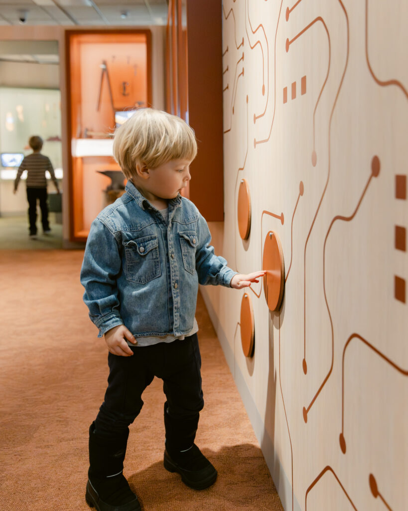 Kokemuksellinen näyttelyarkkitehtuuri museossa, jossa tila kannustaa aistimiseen ja käsillä tekemiseen.