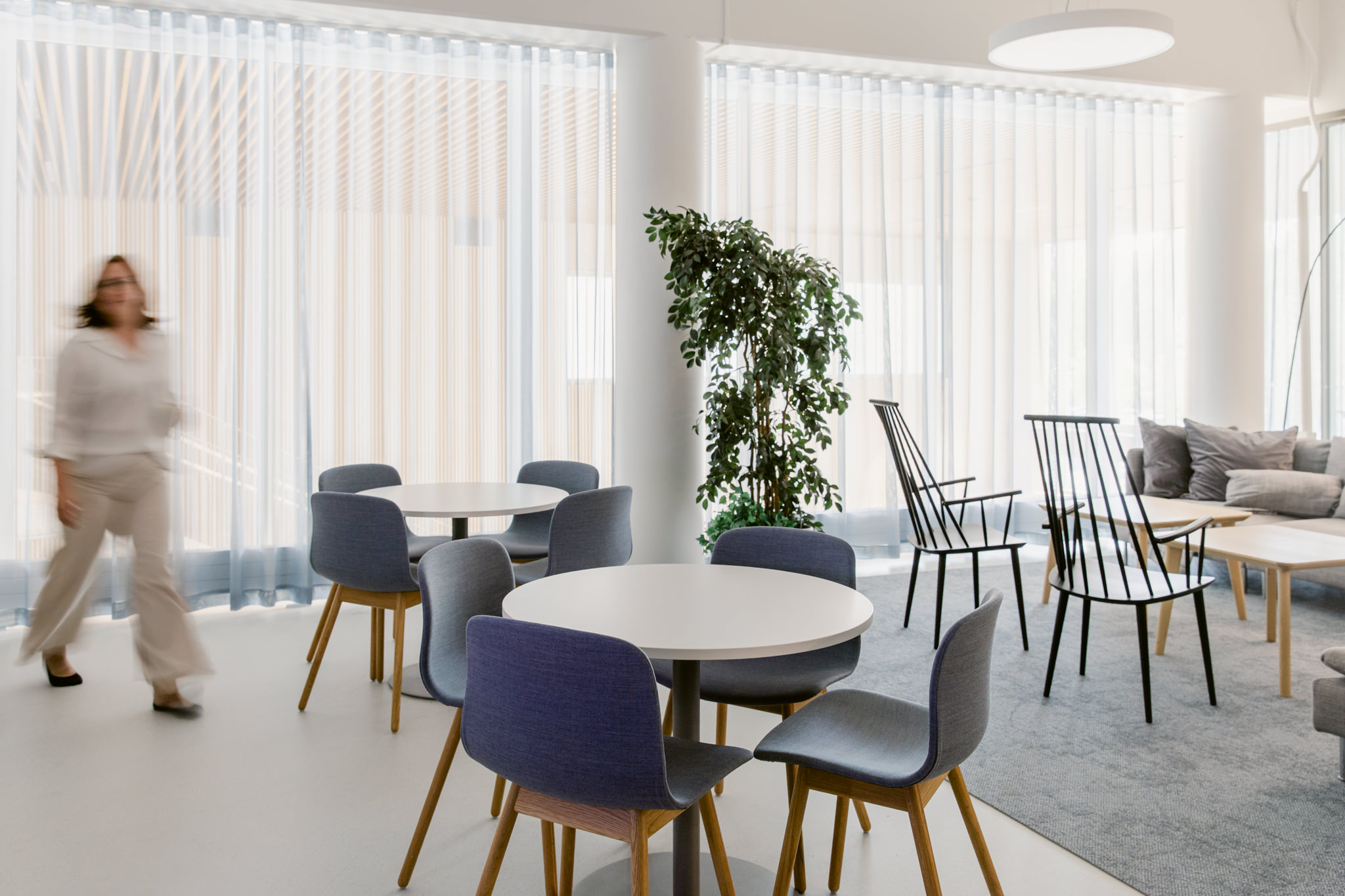 Kestävä toimistosuunnittelu, lounge ja kahvitila Toimiston lounge- ja kahvitila, pyöreät pöydät ja kierrätetyt tuolit kohtaamiseen
